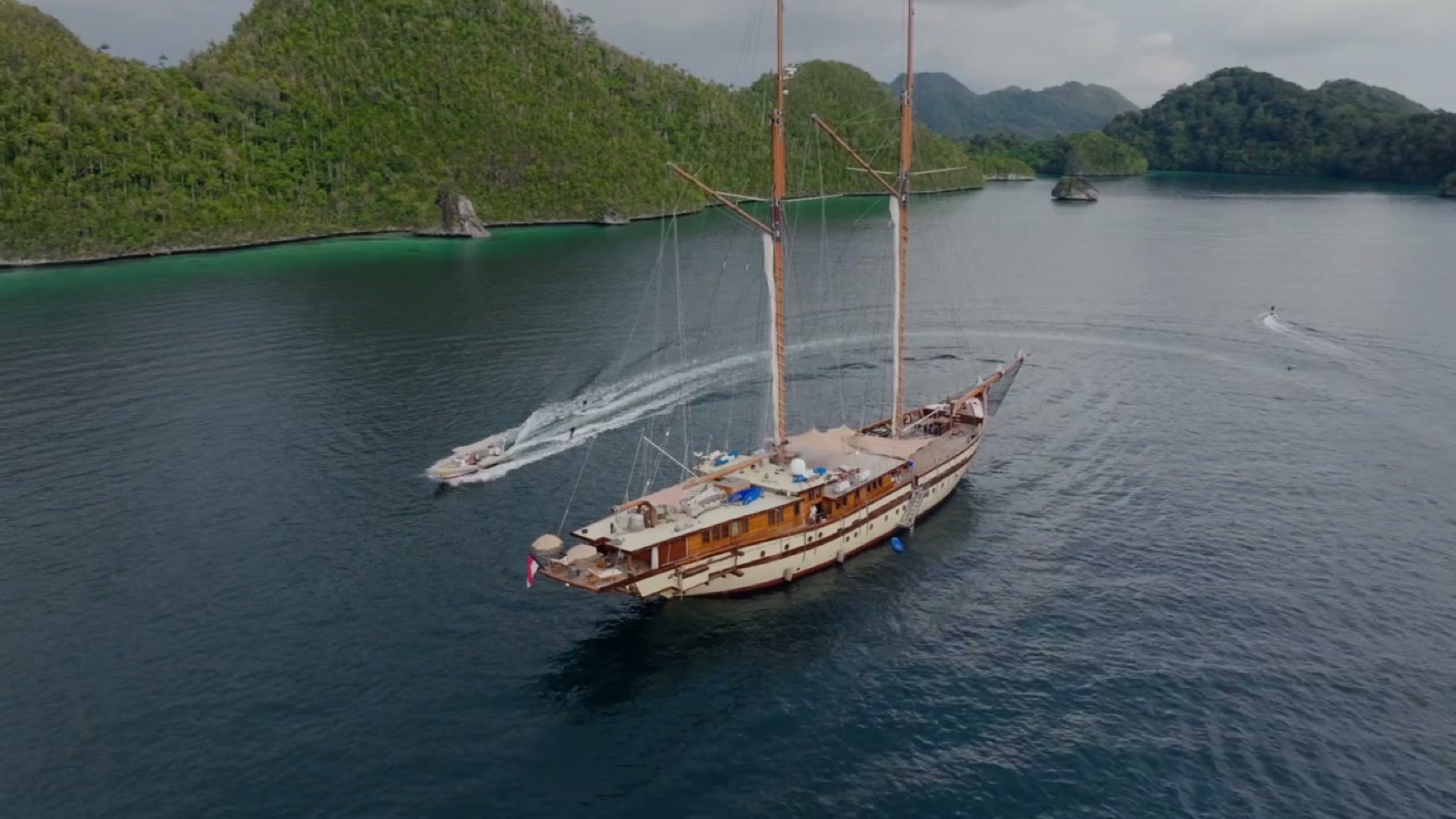 Aerial of a sailing yacht among green islands
