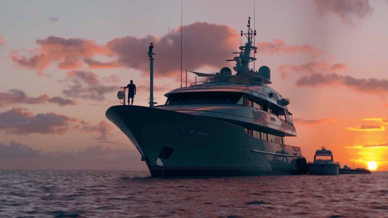 Yacht at anchor at sunset, figure on the bow